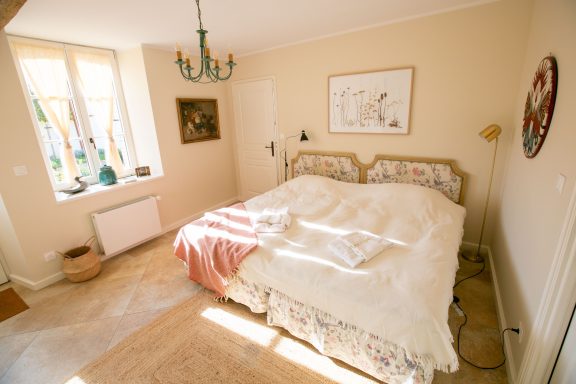Chambre Helles Schlafzimmer mit einem Doppelbett, dekorativem Bettzeug und einem Schreibtisch.